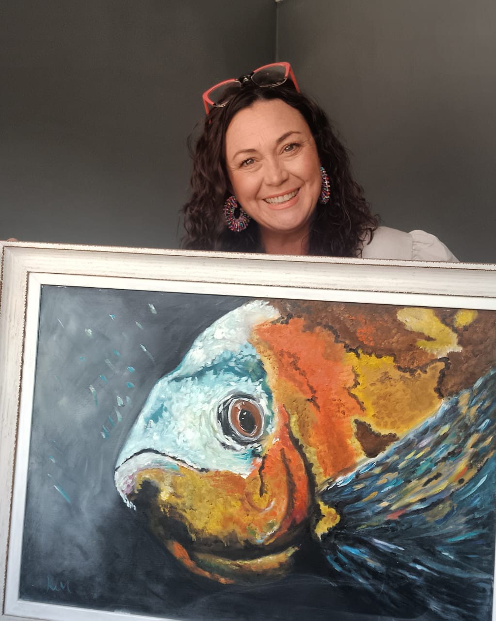 Kim Bezuidenhout in her studio holding Kim with the Fish Painting
