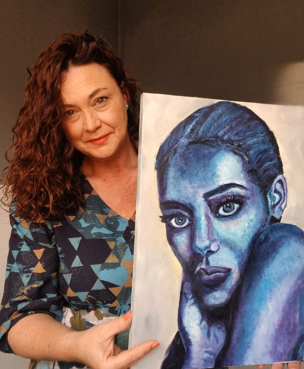Kim Bezuidenhout in her studio holding Kim with the Blue Portrait