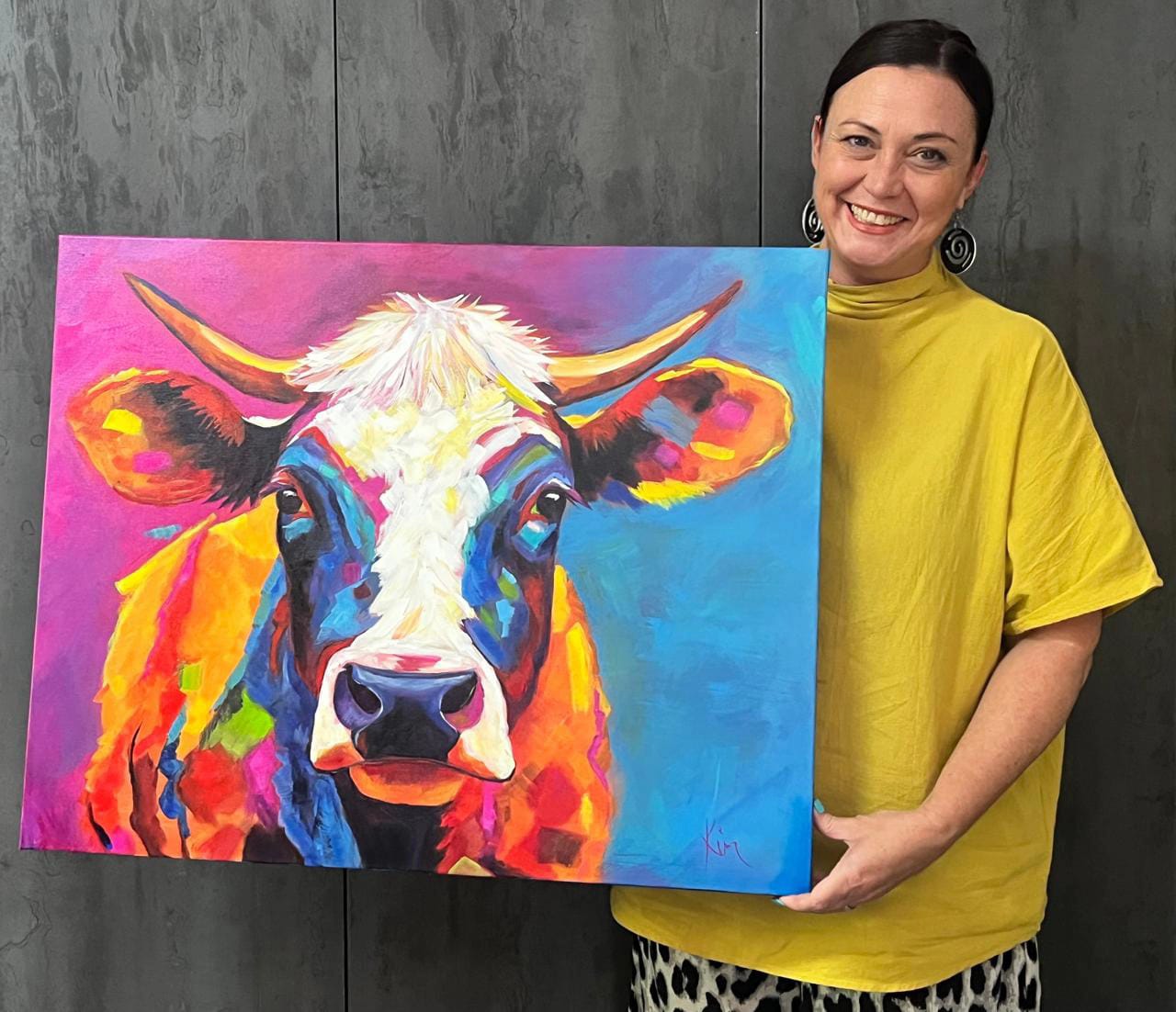 Kim Bezuidenhout in her studio holding Kim with the Pink and Blue Cow