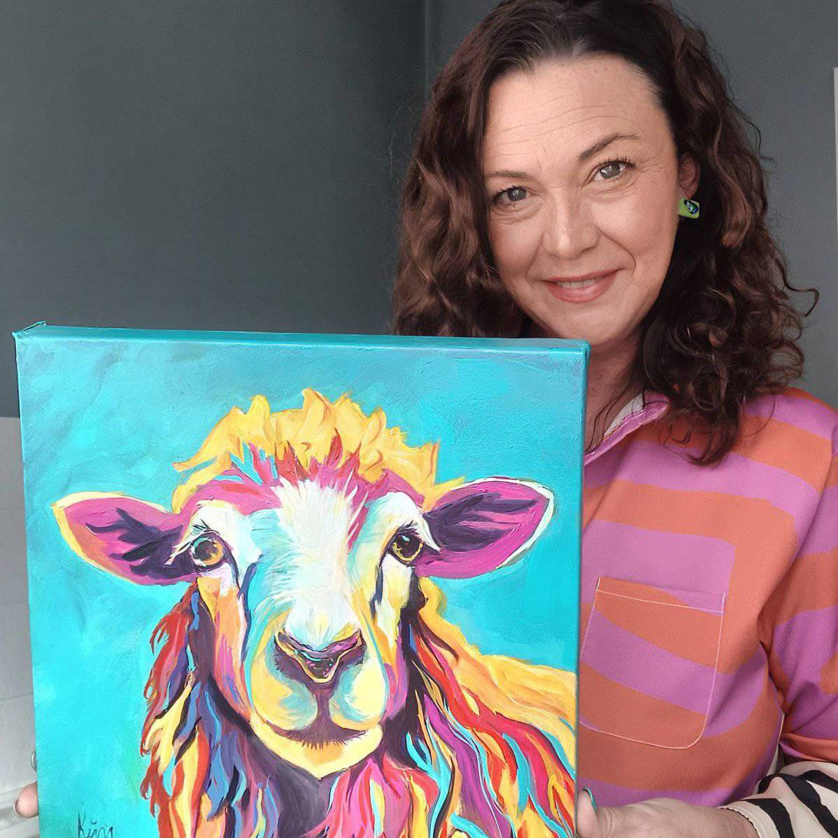 Kim Bezuidenhout in her studio holding Kim with the Teal Sheep