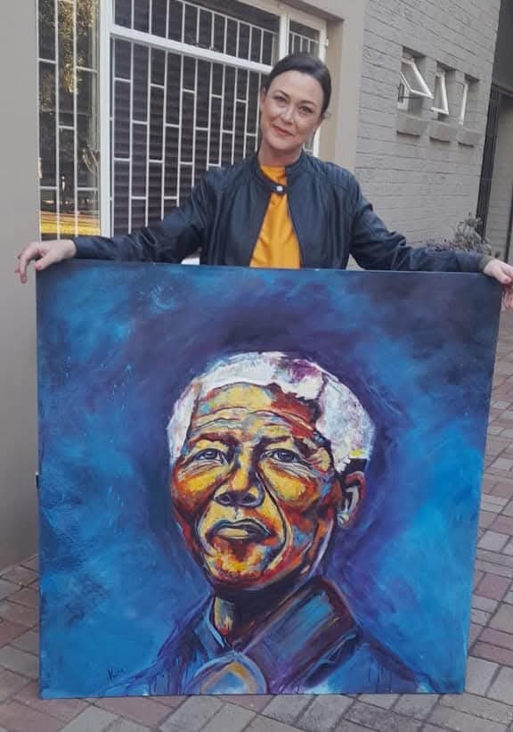 Kim Bezuidenhout in her studio holding Kim with the Mandela Portrait