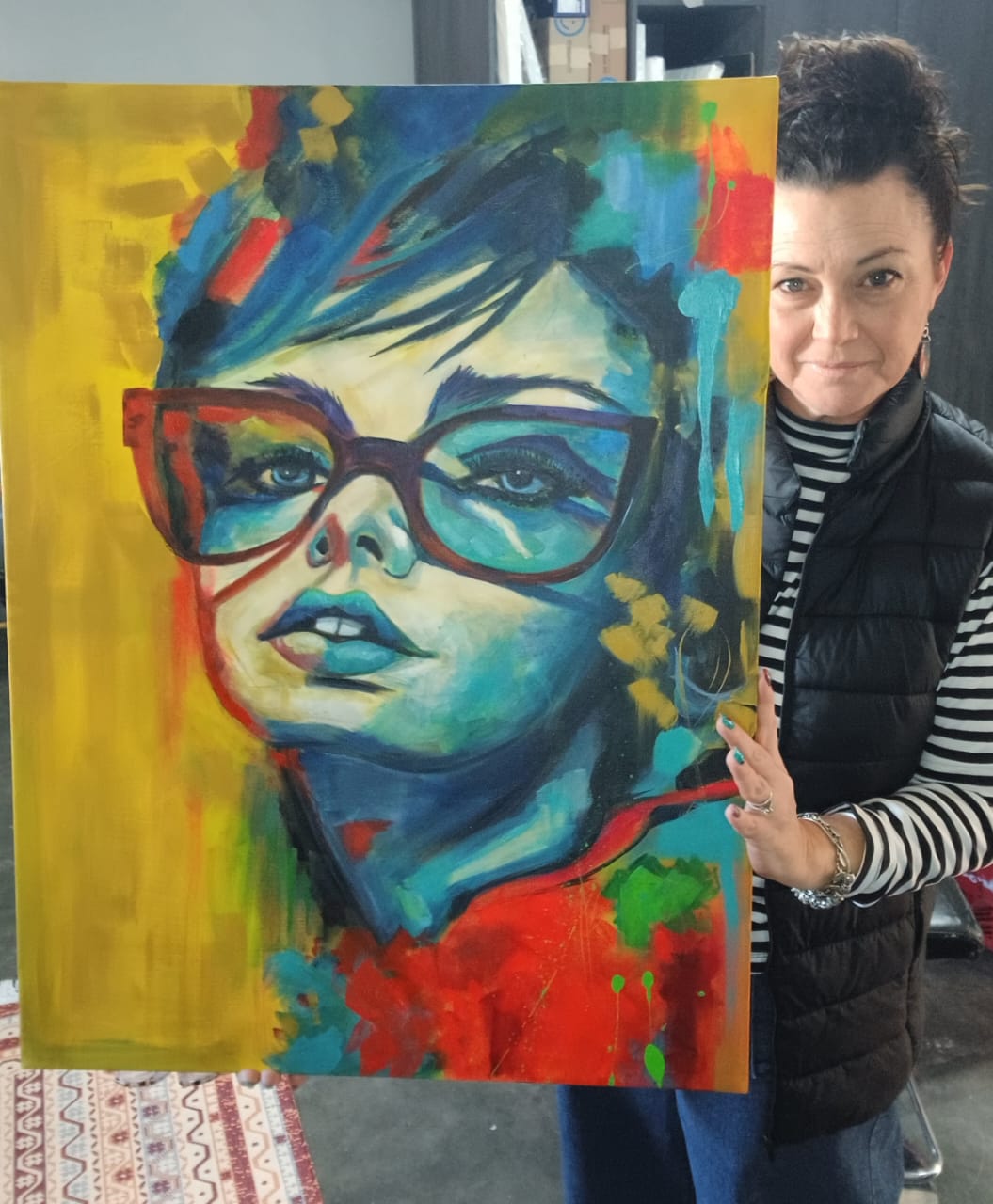 Kim Bezuidenhout in her studio holding Kim with the Blue Glasses Portrait